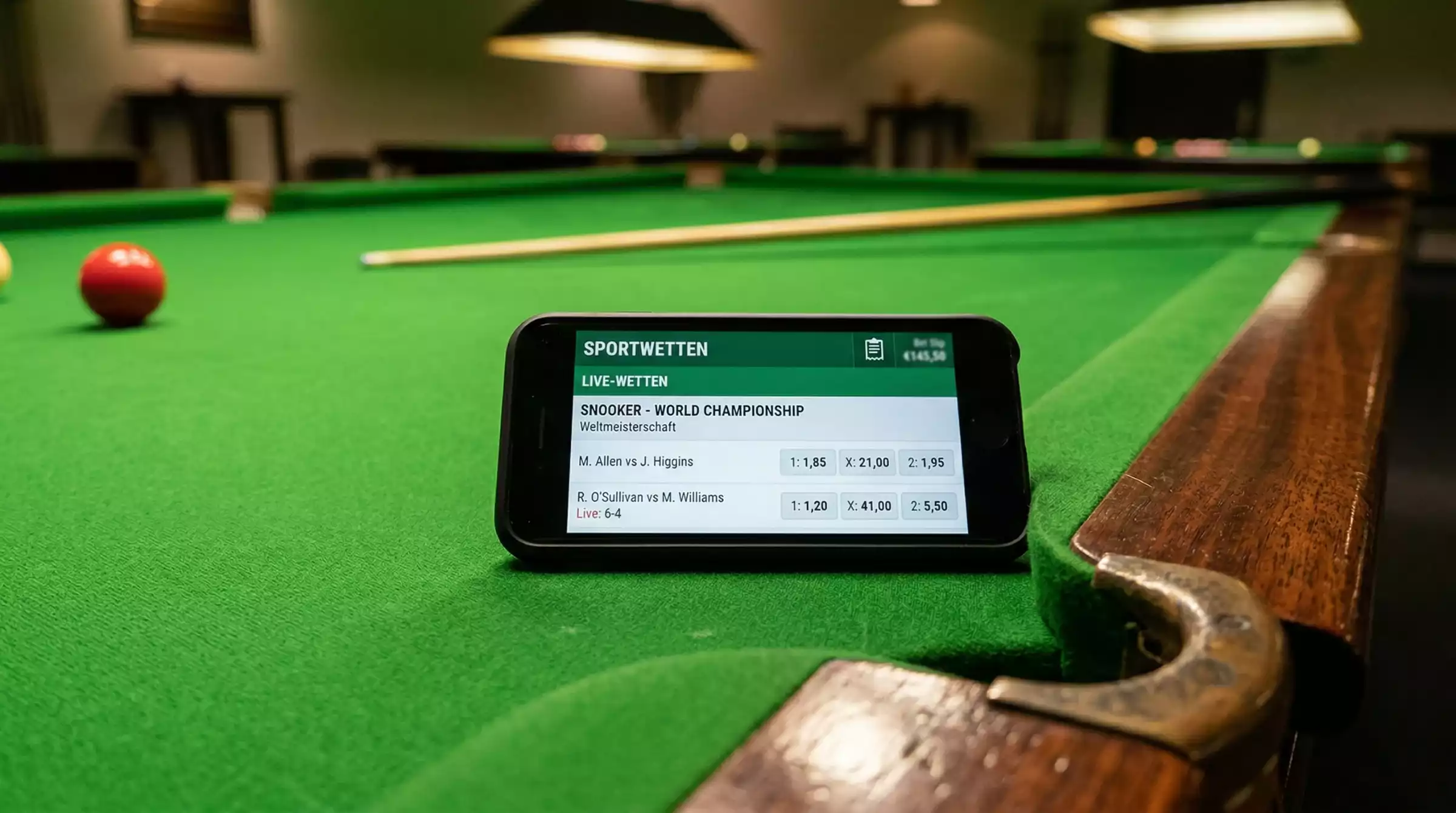 Snooker Wettanbieter Deutschland: Smartphone mit Wett-App neben einem Snookertisch